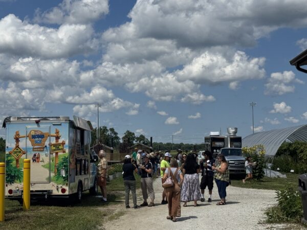Participants gather near food trucks and refreshment vendors during a field day event.
