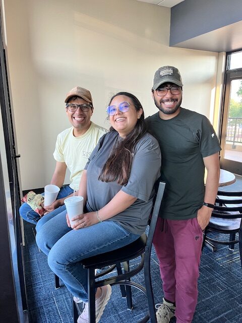 Three attendees pose together inside the suite overlooking the baseball field at the Lafayette Aviators game.