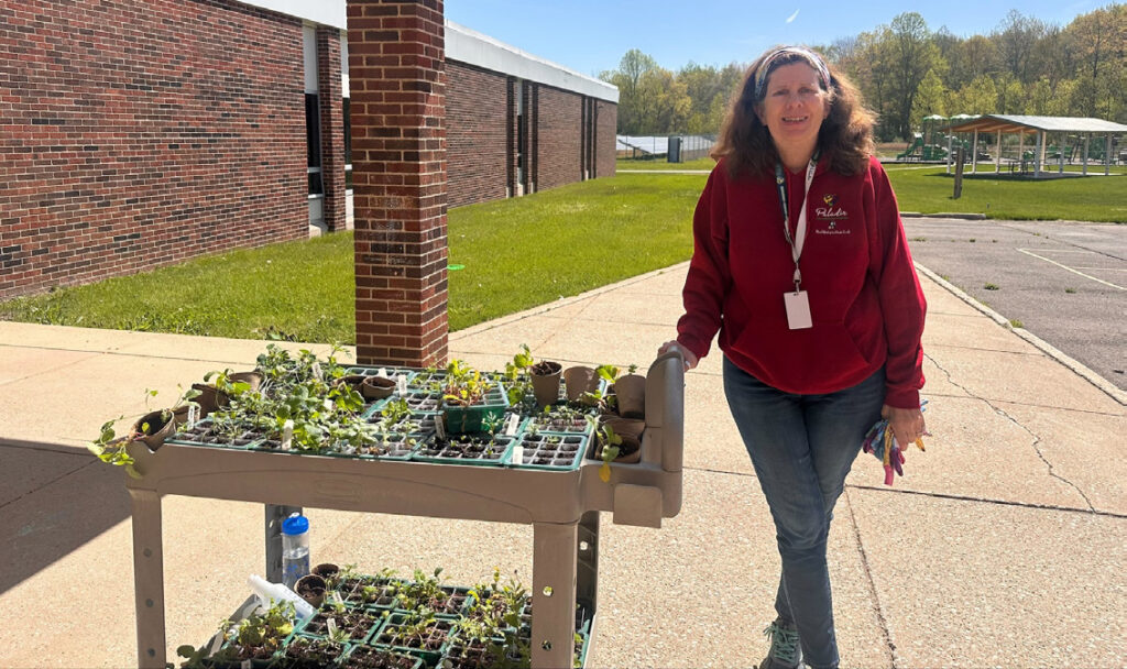 Master Gardener outside a school with a cart full of plants.