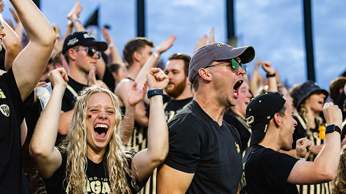 Purdue University students cheering at football game.