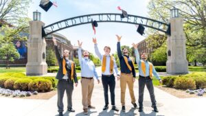 Purdue University graduates throwing their caps in the air.