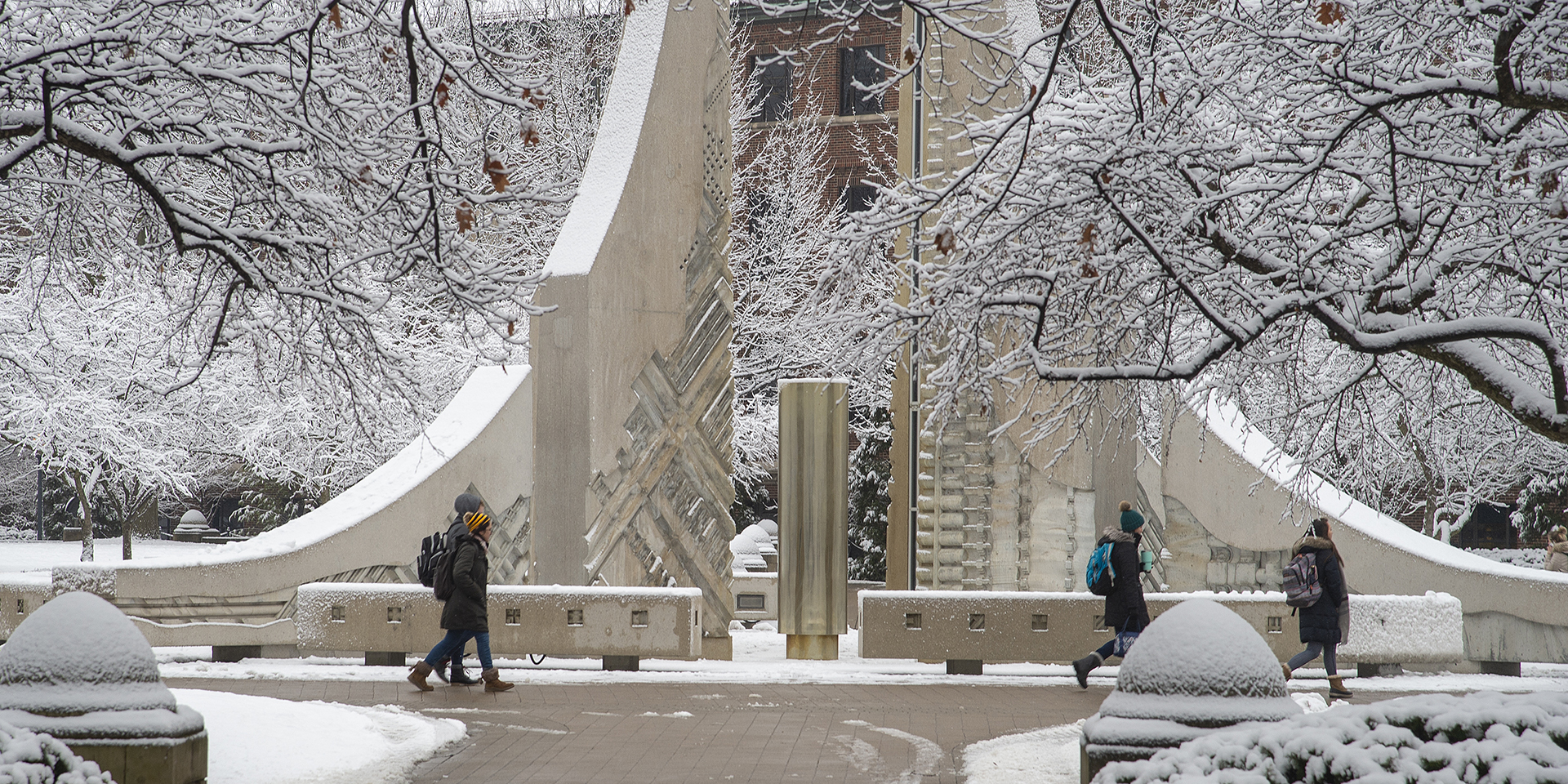 Students walking on snowy Engineering mall.