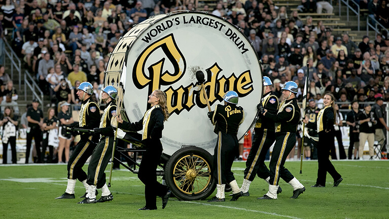 The World's Largest Drum being played by the Purdue University band on the football field.