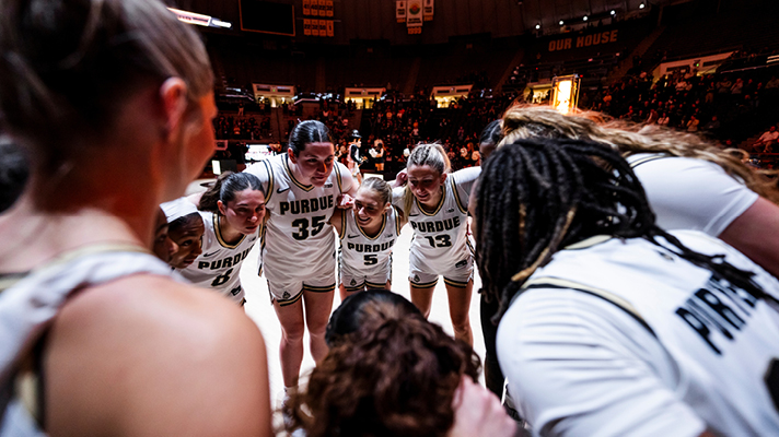 Purdue women’s basketball players in a huddle.