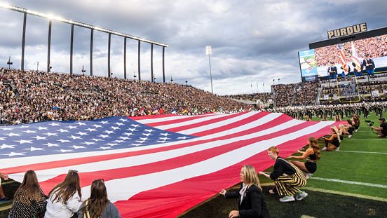 Purdue students unfurling an American Flag at Ross-Ade Stadium.