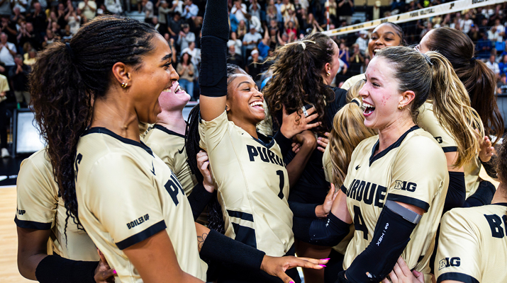 Purdue women's volleyball team celebrating a point on the court.