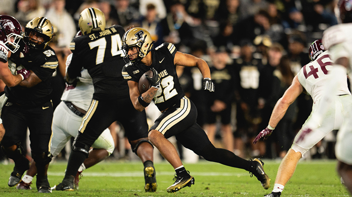 Purdue football player carrying the ball during a game.
