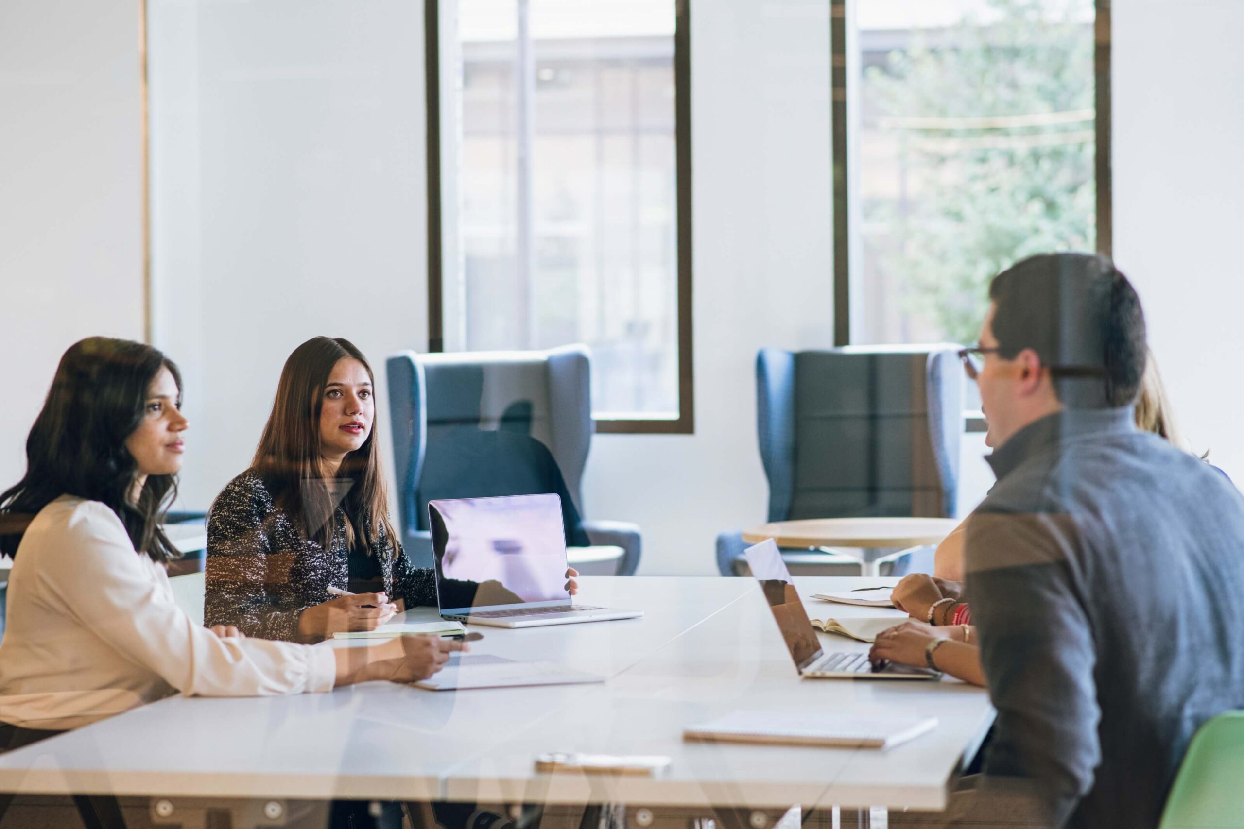 Three people sitting at a desk