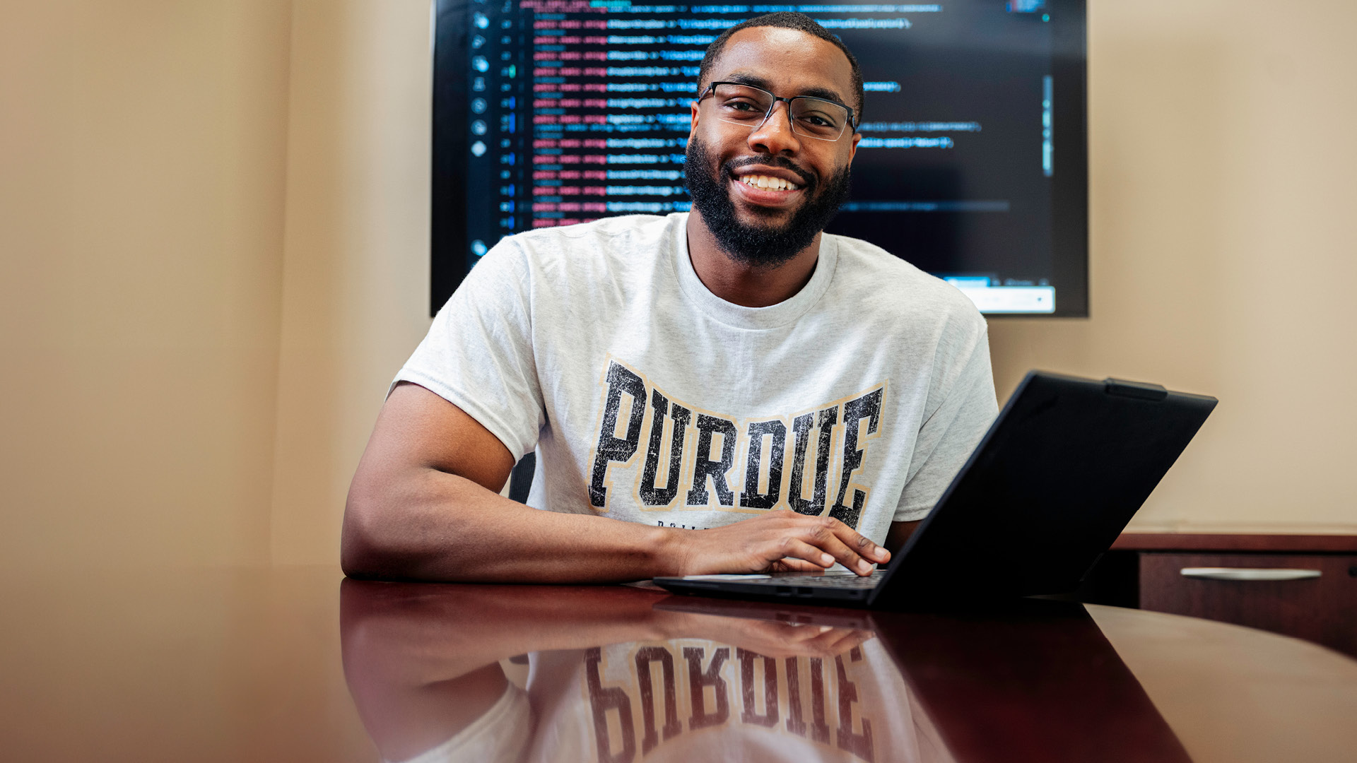 Student sits at desk with an open laptop
