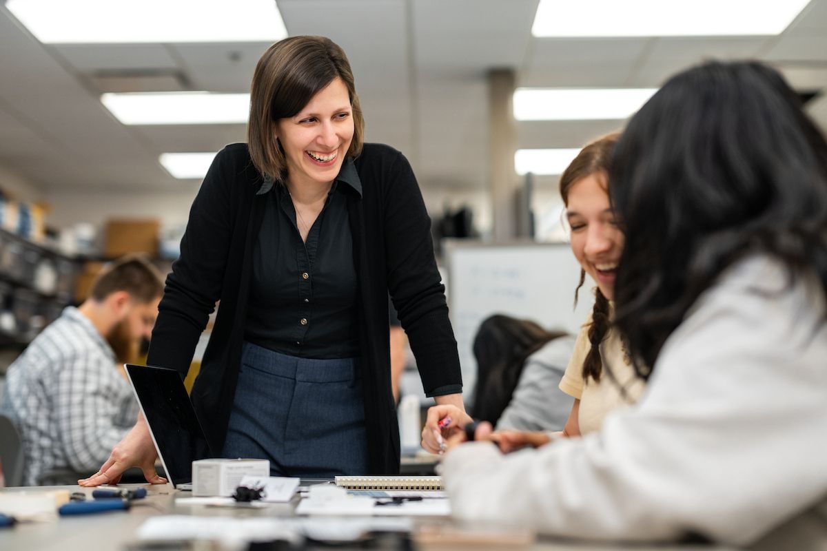 Professor teaching and smiling at students in a classroom