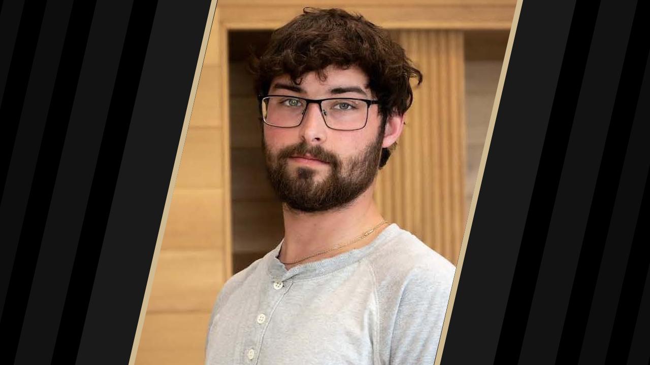 Portrait photo of person wearing glasses and grey shirt