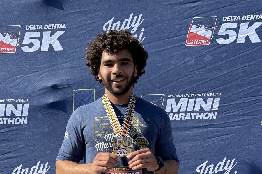 Person holds his medal after finishing the IU Health 500 Festival Mini-Marathon.