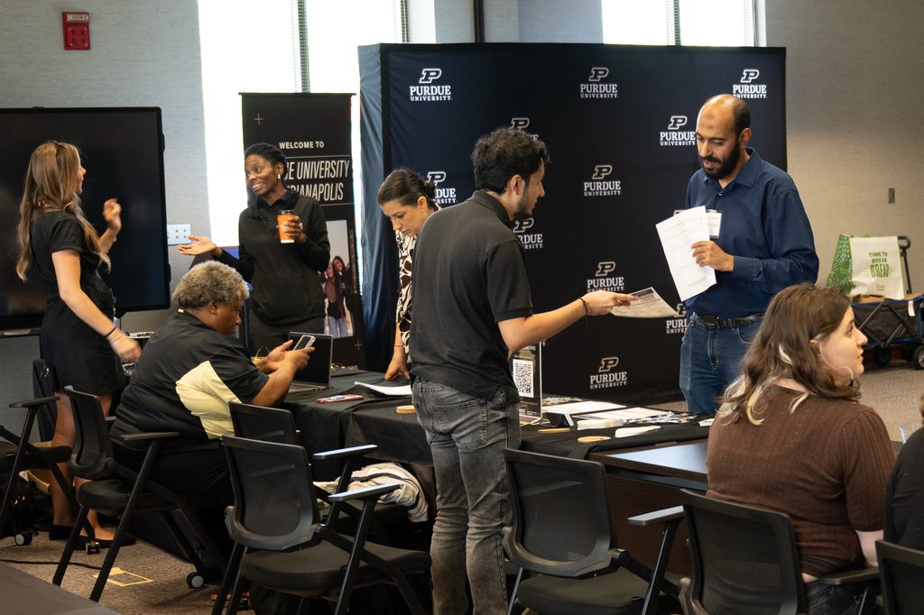 Attendees speak with Purdue Indianapolis representatives at an information table.