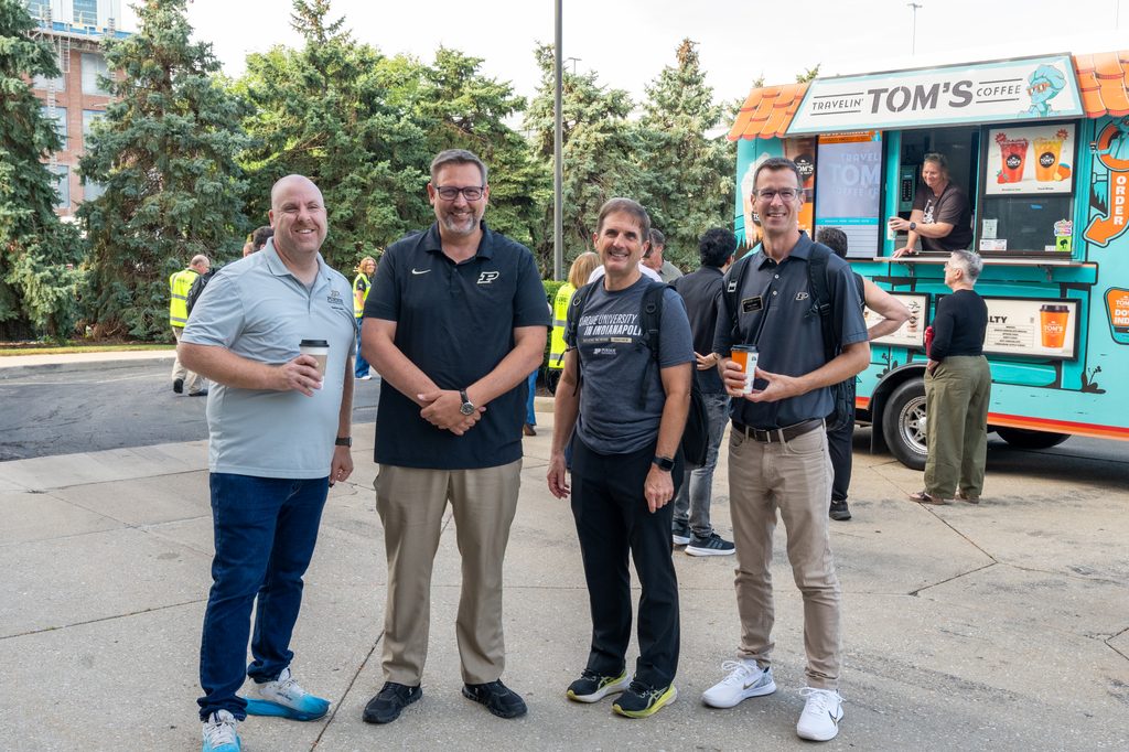 Four attendees stand near Tom’s Coffee Truck during the Purdue Indianapolis Fall Launch.