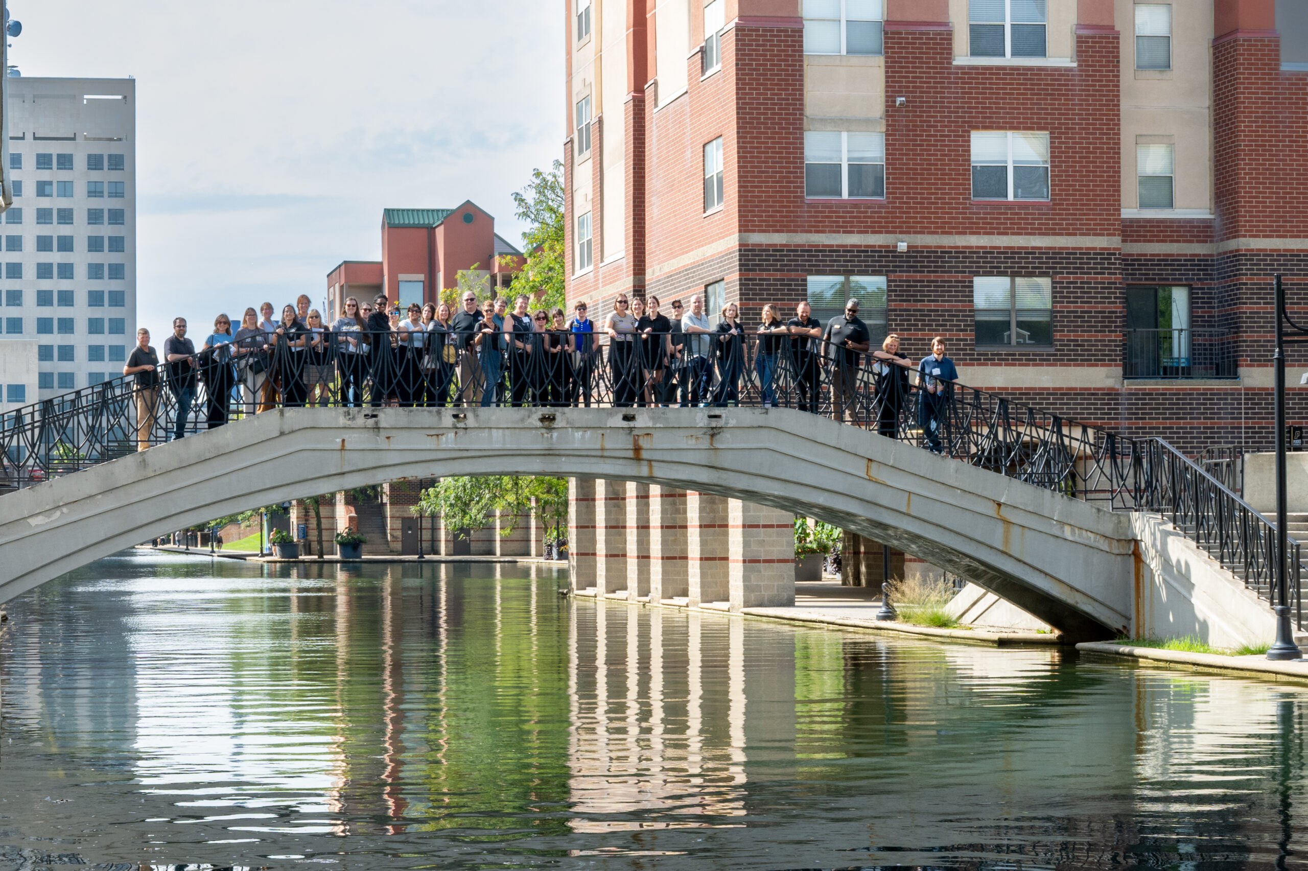 Purdue faculty and staff members stand on a bridge over the Central Canal during a campus tour.