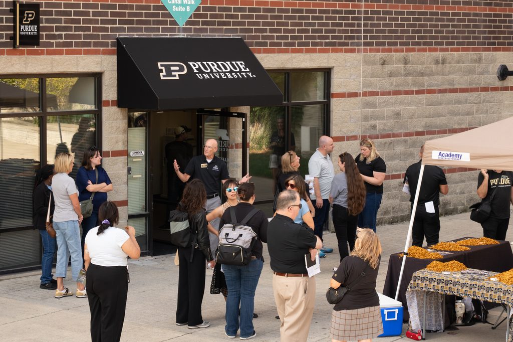 Tour participants gather outside a Purdue Indianapolis building before a guided visit.