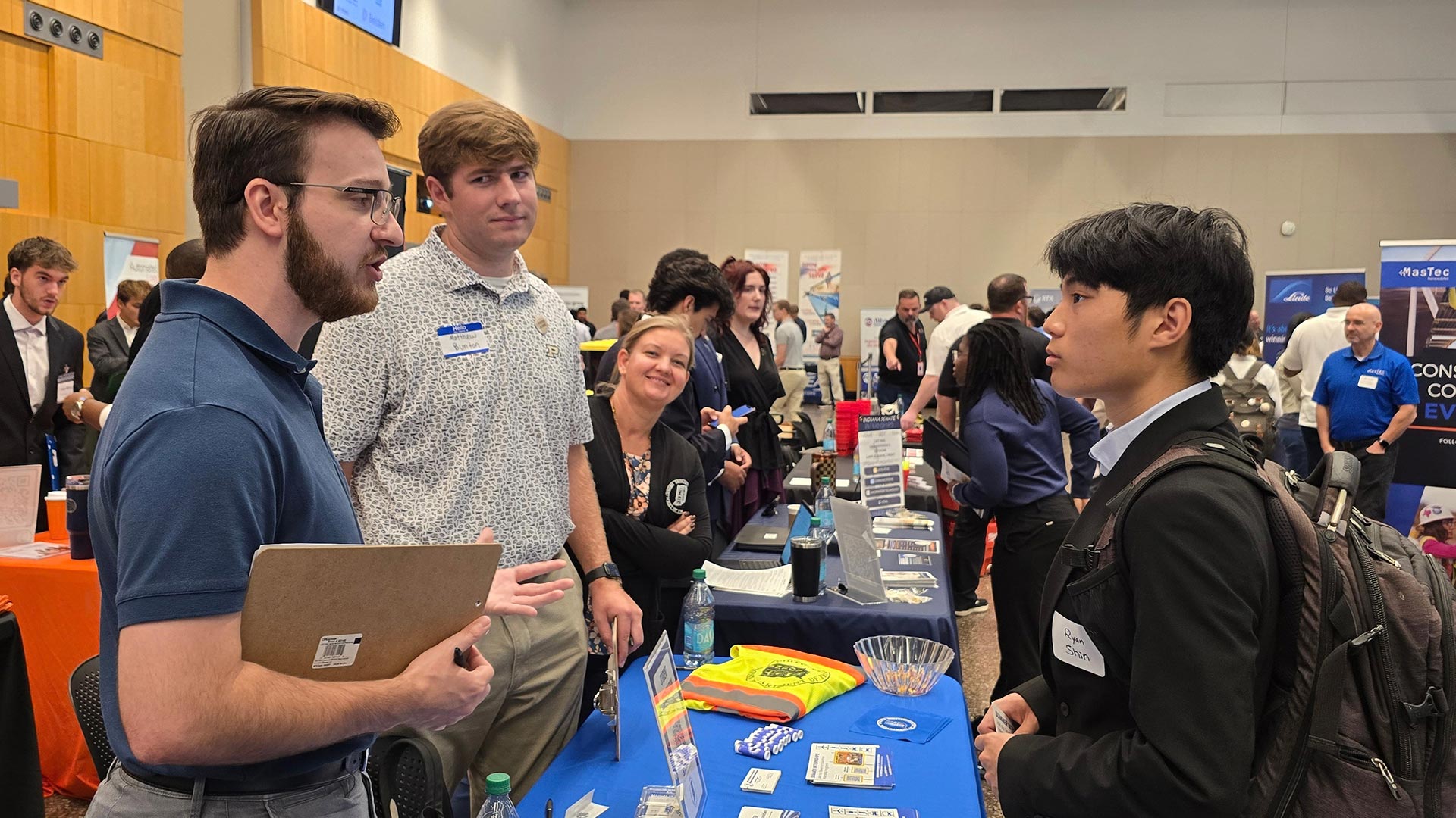 INDOT representatives speak with a student at a recruiting table during the Purdue in Indianapolis Industry Fair.