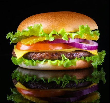 A hamburger with lettuce, cheese, tomato, and onion.