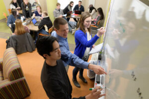 Students writing on white boards