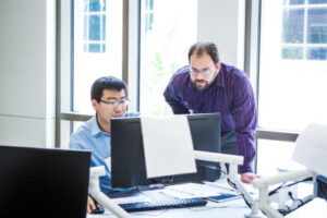 Professor and student looking at computer
