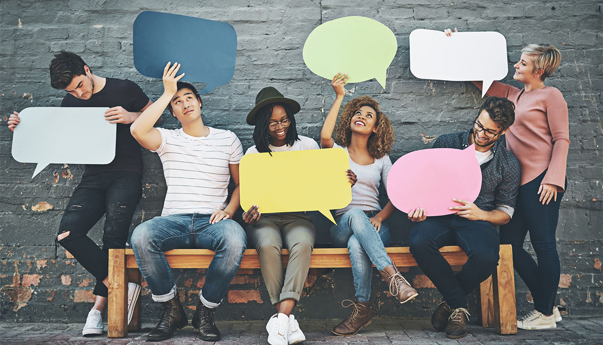 Shot of a diverse group of people holding up speech bubbles outside