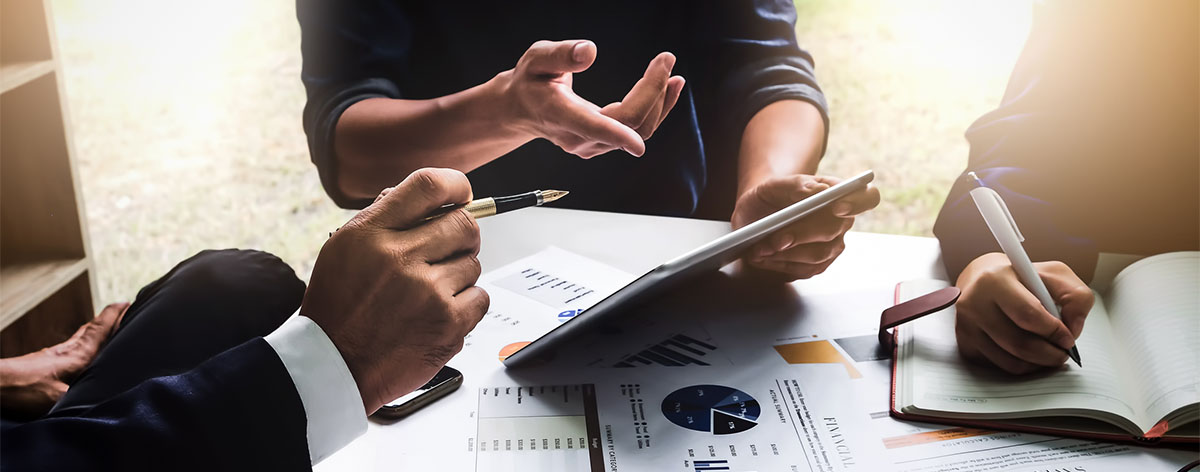 Business people using pen,tablet,notebook are planning a marketing plan to improve the quality of their sales in the future.