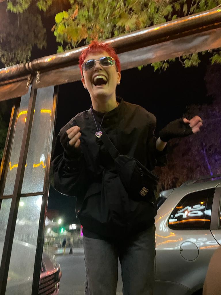 image of student laughing at a bus stop