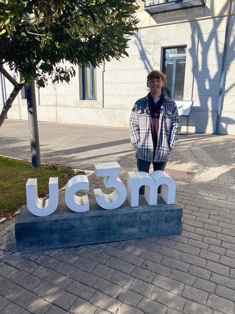 Aidan Anastario poses with UC3M sign on campus