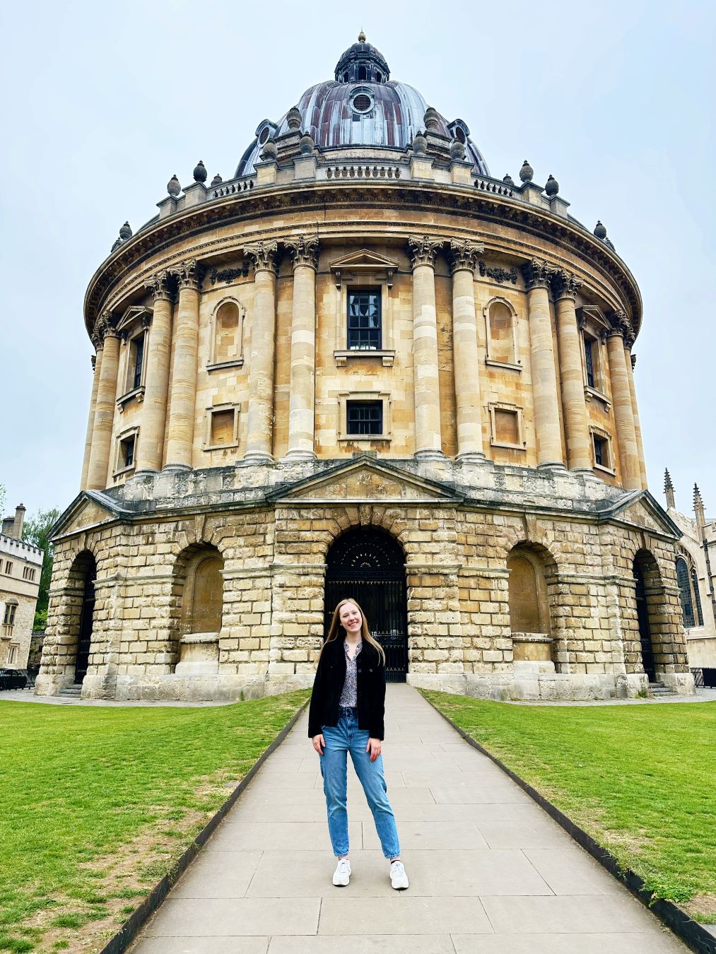 Anna Shura stands in front of a round building at Oxford University