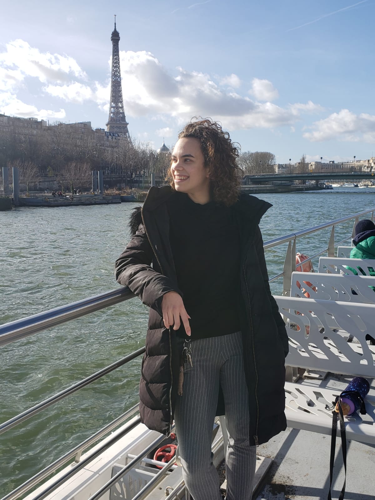 Mari Morais on a boat on the Seine river in Paris with the Eiffel Tower in the background
