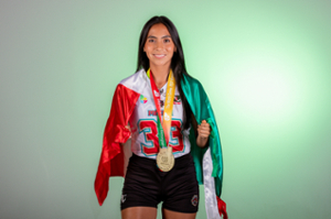 woman with long dark hair in flag football uniform wrapped in Mexico's flag