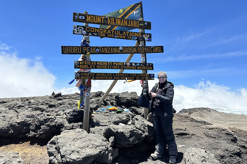 Heather Sager holds her Purdue Global water bottle at the top of Mount Kilimanjaro.