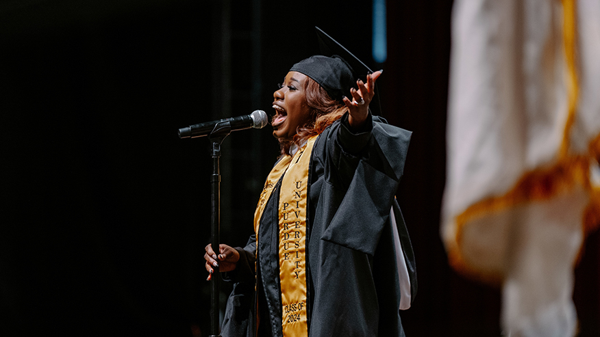 Purdue Global alumna Ebony Collier sings the national anthem during commencement.