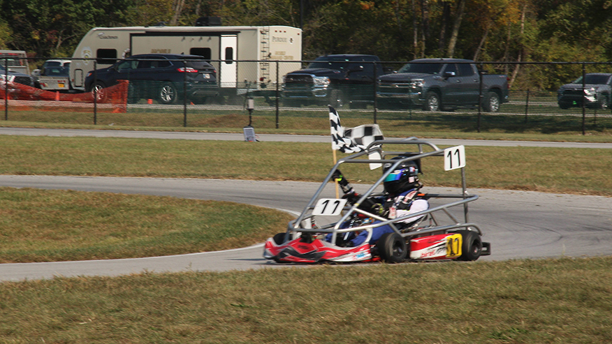 Student waving the checkered flag at the Halloween Hundred