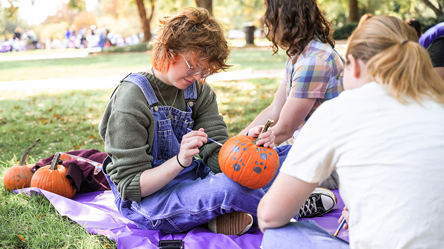 Student painting a pumpkin