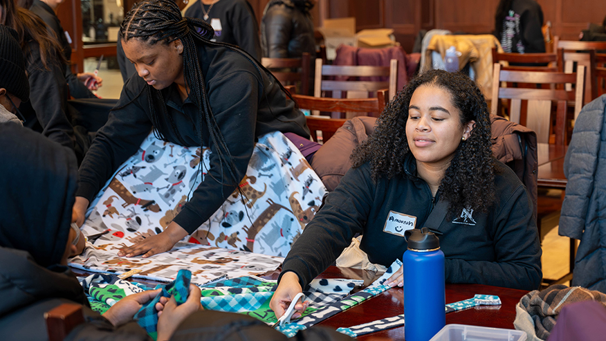 Student cutting material while seated at table