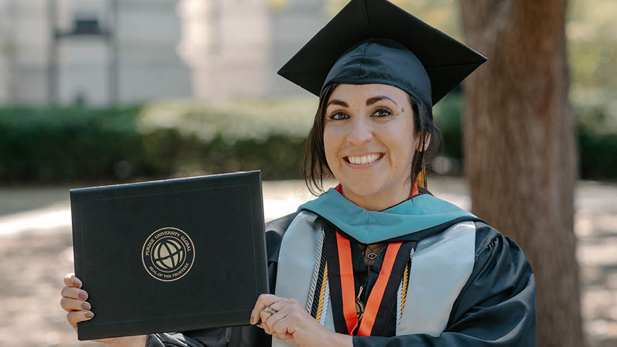 Woman holding diploma in cap and gown
