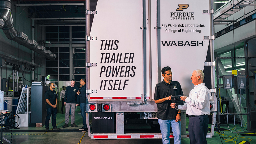 Group standing around semi truck