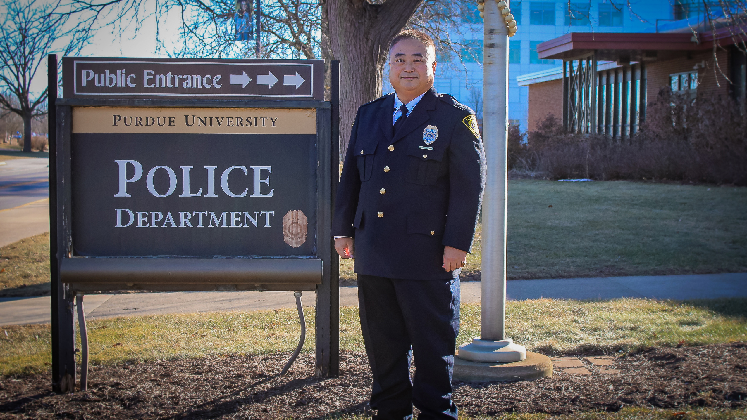Man in police uniform standing next to sign