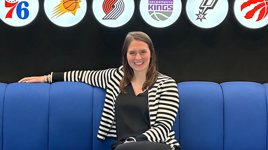 Girl sitting on couch with basketball logos in background