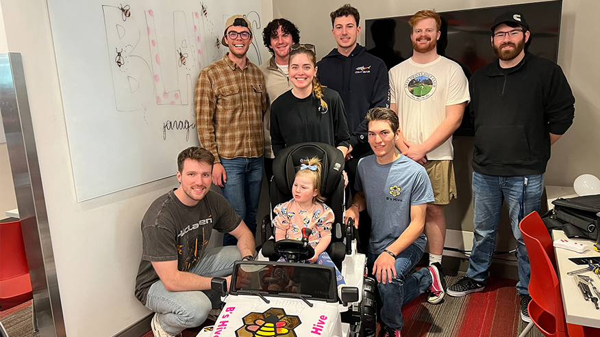 Engineering and Physical Therapy students from Purdue and IU present Blaire her custom car as part of the GoBabyGo program.