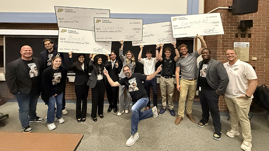 A group shot of students holding up five giant checks from Purdue University.