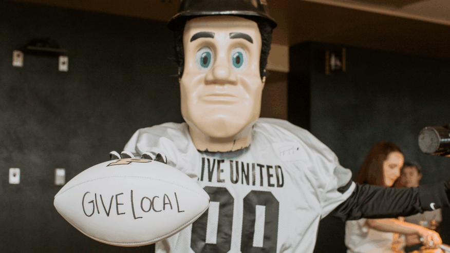 Purdue Pete wears a United Way jersey and holds a football with the message, “Give Local.”