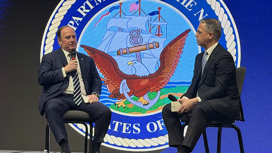 Secretary of the Navy John Phelan, left, talks with Sen. Jim Banks, R-Ind., right, sit on stage at the Northeast Indiana Defense Summit