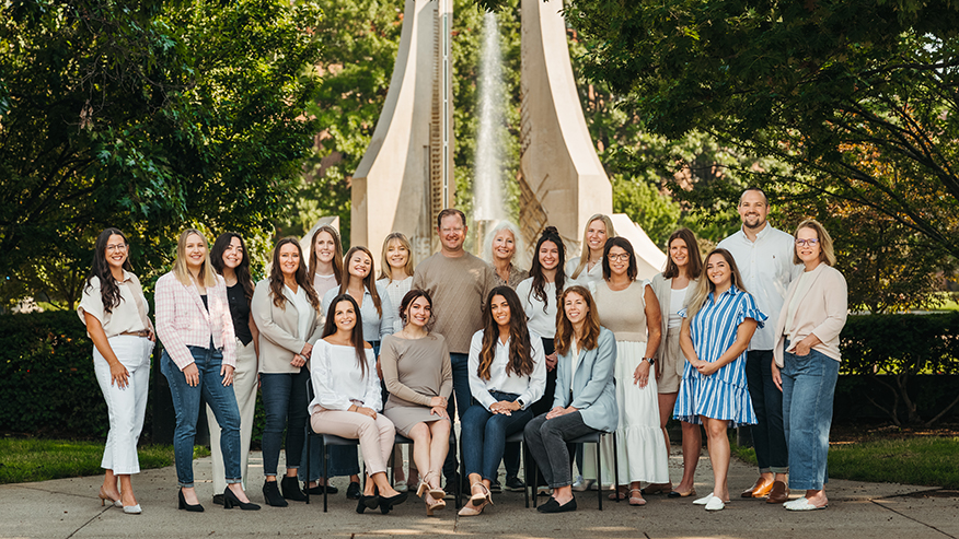 A group of people stand in front of Purdue’s Class of 1939 Water Sculpture.