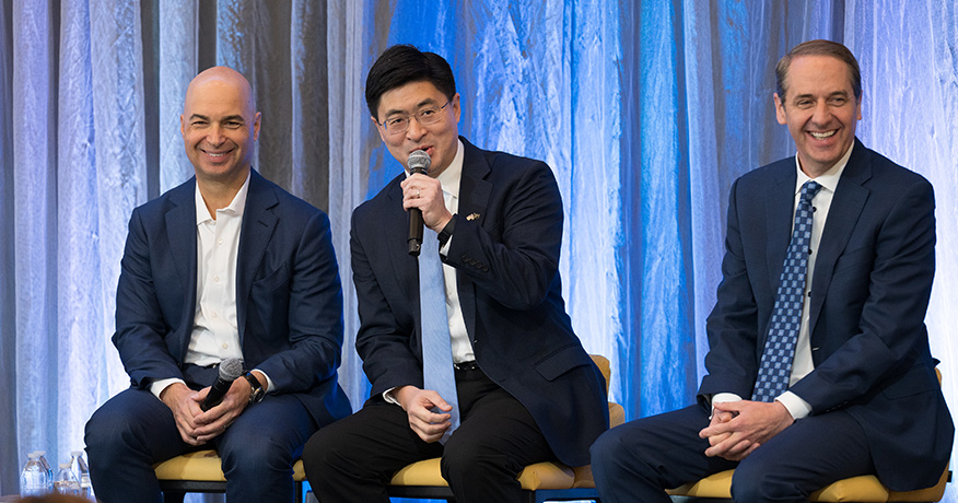 Three men on stage during panel