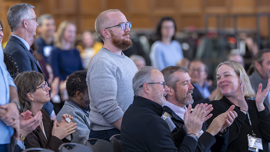 People stand for recognition while others clap