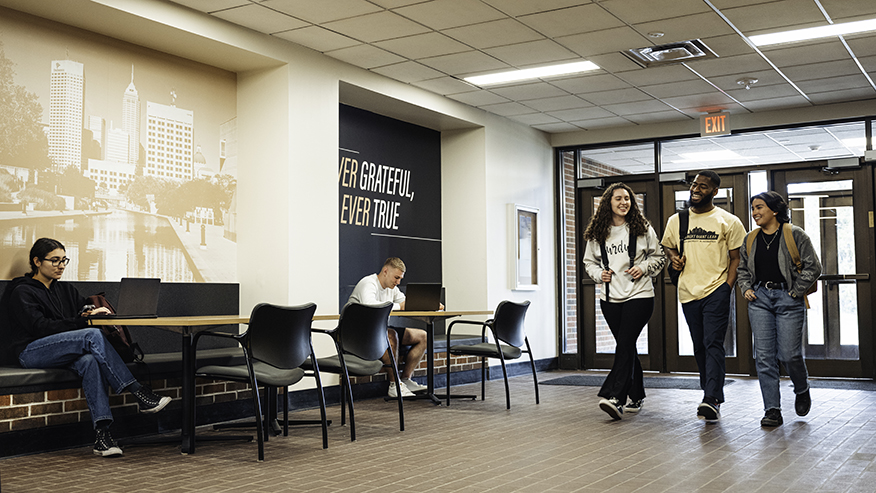 Students walk and study in a Purdue University building.