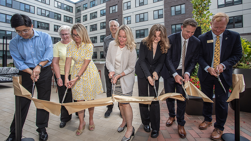 People cutting a ribbon at a ceremony
