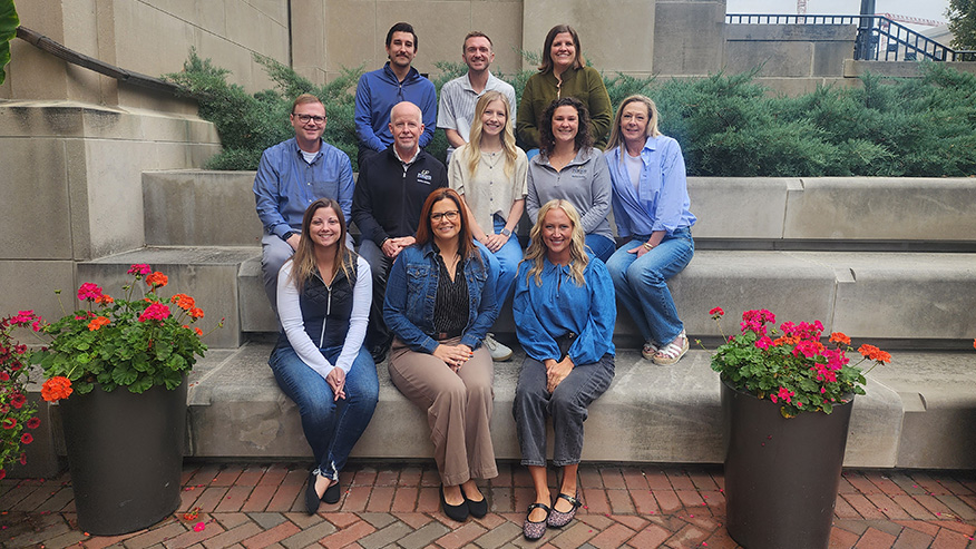 A group of 11 staff members sitting together.